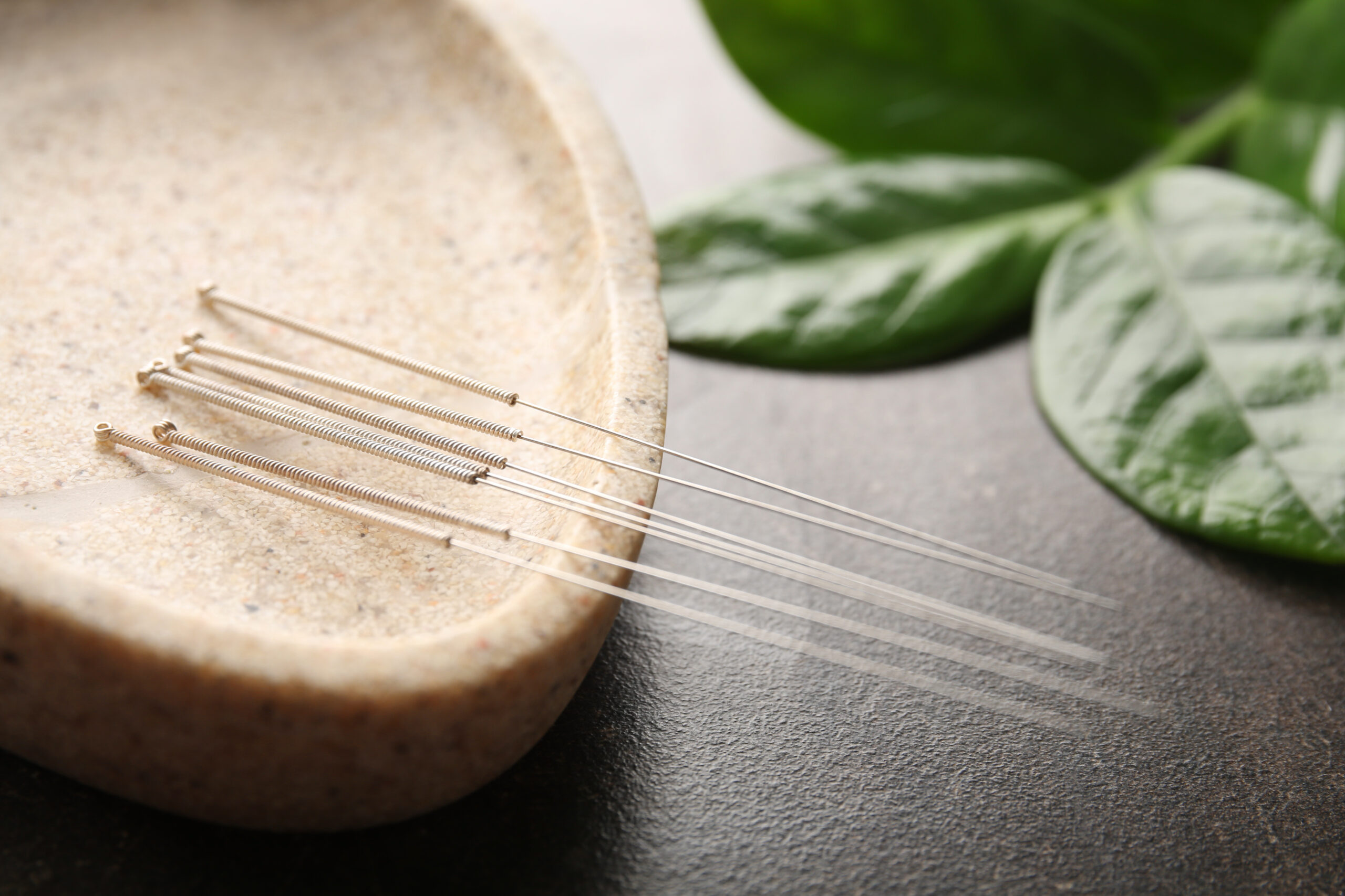 Special stand with needles for acupuncture on dark background, c